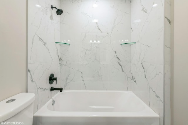 bathroom with toilet and tiled shower / bath