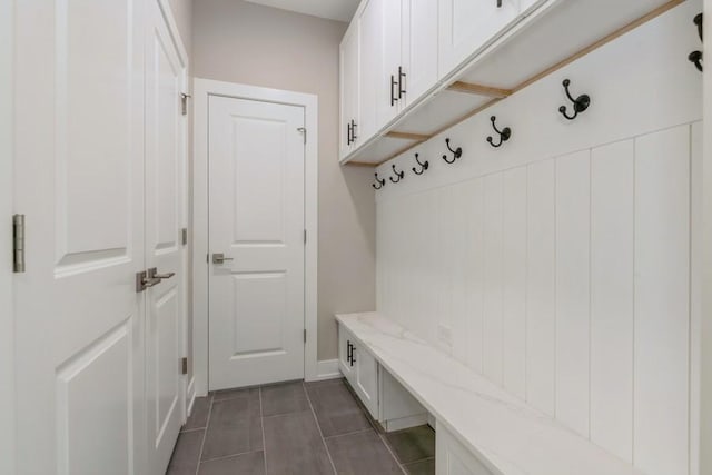 mudroom with dark tile patterned flooring