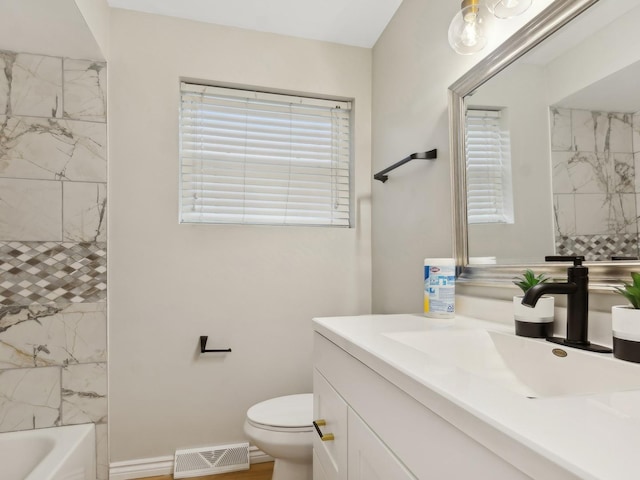 full bathroom featuring vanity, toilet, and tiled shower / bath