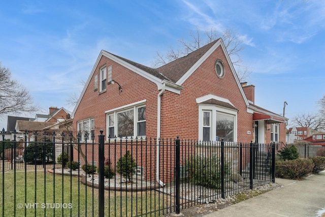 view of home's exterior featuring a fenced front yard, brick siding, and a lawn