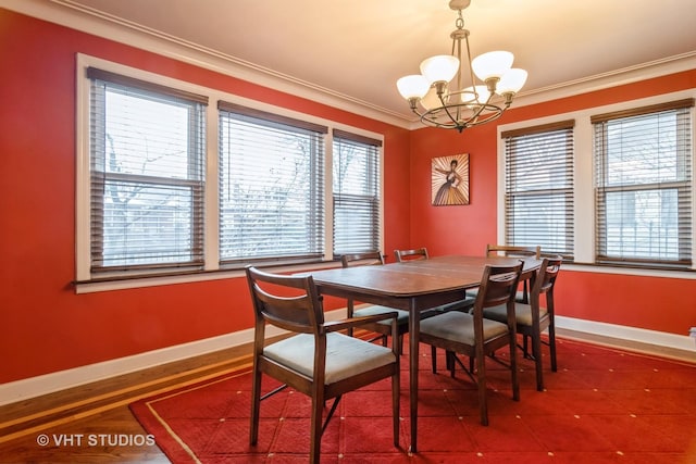 dining area with a notable chandelier, crown molding, and baseboards