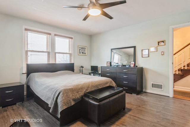 bedroom featuring a ceiling fan, baseboards, visible vents, and wood finished floors