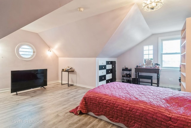 bedroom featuring lofted ceiling, wood finished floors, and baseboards