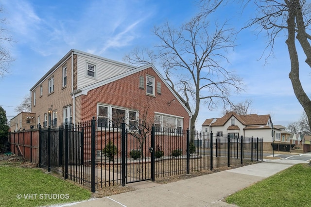 view of side of home with a fenced front yard and brick siding