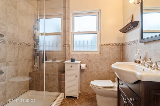 full bath with a wealth of natural light, tiled shower, vanity, and tile walls