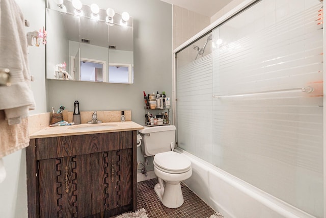 full bathroom featuring toilet, vanity, tile patterned floors, and shower / bath combination with glass door