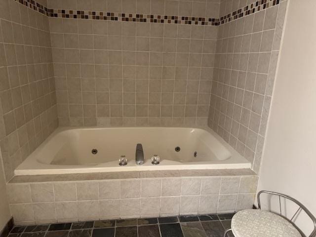 bathroom with tile patterned floors, toilet, and tiled shower / bath