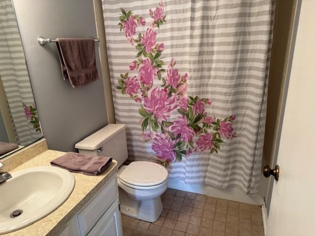 full bathroom with tile patterned flooring, shower / bath combo with shower curtain, vanity, and toilet