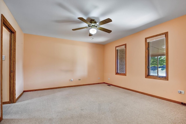 spare room featuring light carpet and ceiling fan