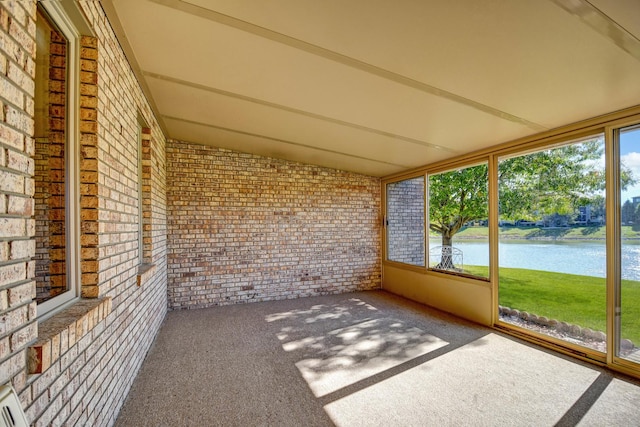 unfurnished sunroom featuring a water view and vaulted ceiling