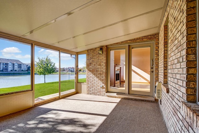 unfurnished sunroom with a water view and vaulted ceiling