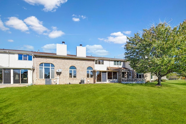 back of house featuring a lawn and central AC