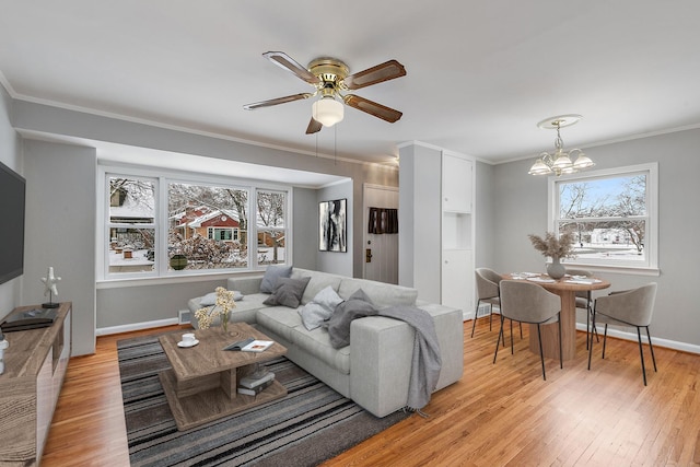 living room featuring crown molding, light hardwood / wood-style flooring, and ceiling fan with notable chandelier