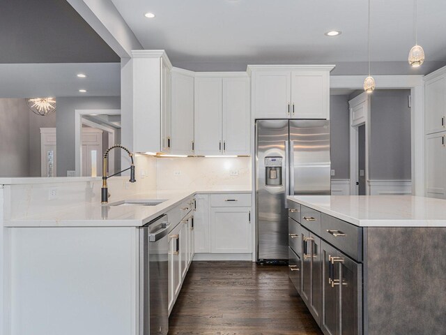 kitchen with appliances with stainless steel finishes, white cabinetry, and light stone counters