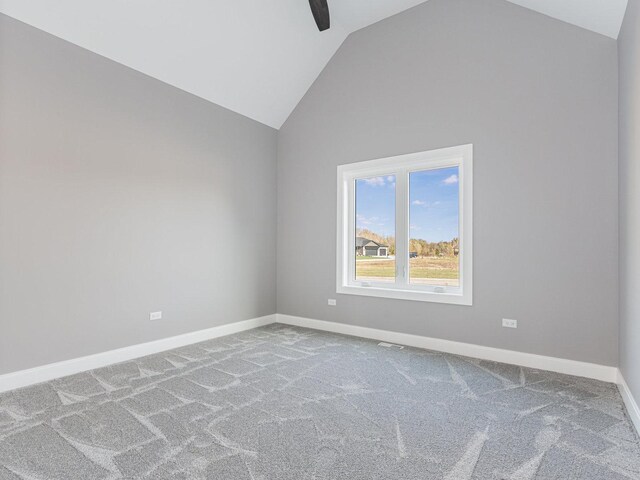 spare room with carpet flooring and vaulted ceiling