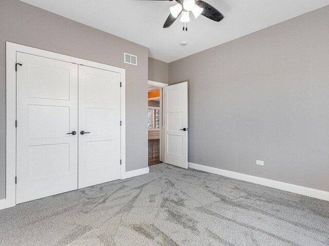 unfurnished bedroom with ceiling fan, light carpet, and a closet