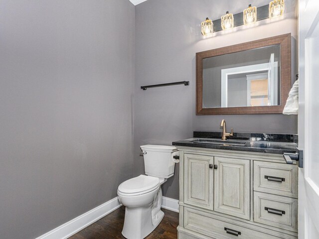 bathroom with hardwood / wood-style floors, vanity, and toilet