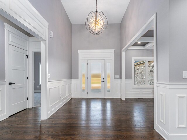 foyer entrance with dark hardwood / wood-style flooring, elevator, and a notable chandelier