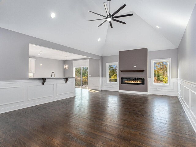 unfurnished living room with ceiling fan, dark hardwood / wood-style flooring, a fireplace, and high vaulted ceiling