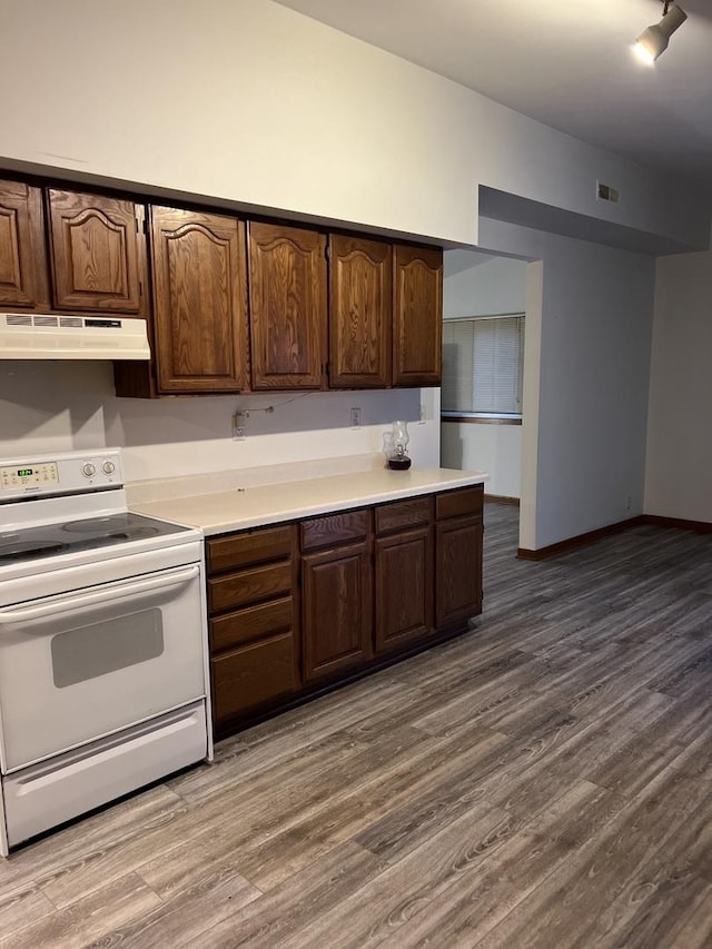 kitchen featuring dark brown cabinetry, electric range, and hardwood / wood-style floors