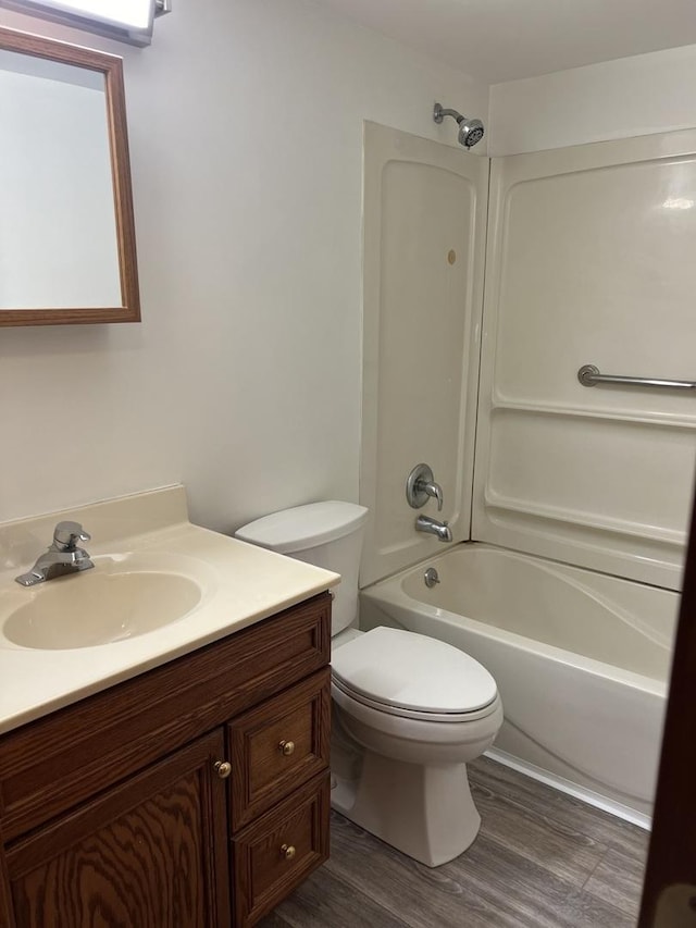 full bathroom with hardwood / wood-style flooring, vanity, toilet, and shower / bath combination