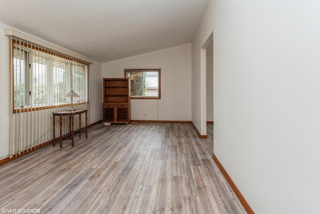 unfurnished room featuring light hardwood / wood-style flooring and lofted ceiling