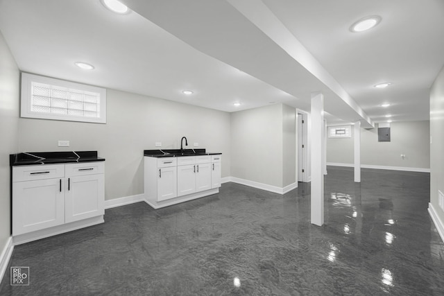 interior space featuring recessed lighting, a sink, electric panel, and baseboards