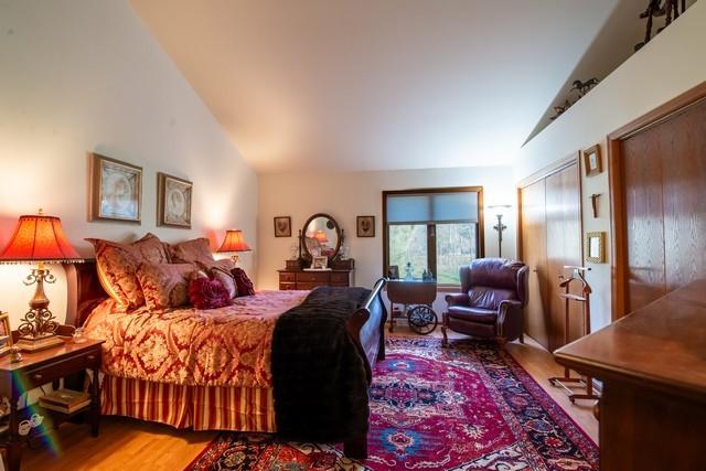 bedroom featuring hardwood / wood-style floors and lofted ceiling