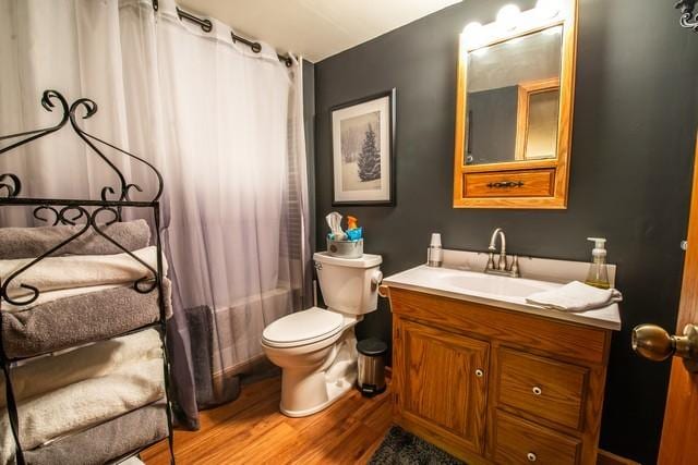 full bathroom featuring shower / bath combo, vanity, hardwood / wood-style flooring, and toilet