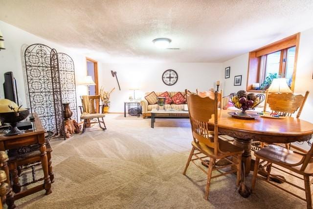 dining space featuring a textured ceiling and carpet floors