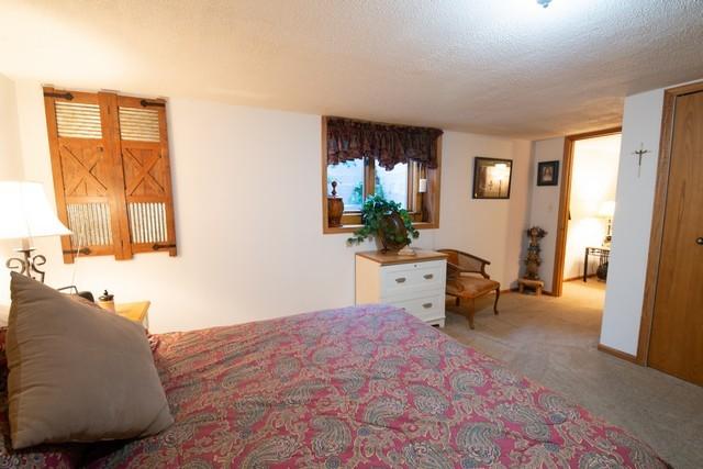 bedroom with light colored carpet and a textured ceiling