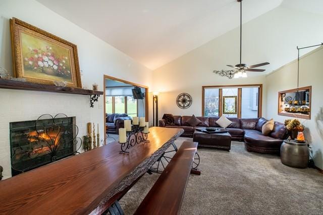 carpeted living room with ceiling fan, plenty of natural light, and high vaulted ceiling