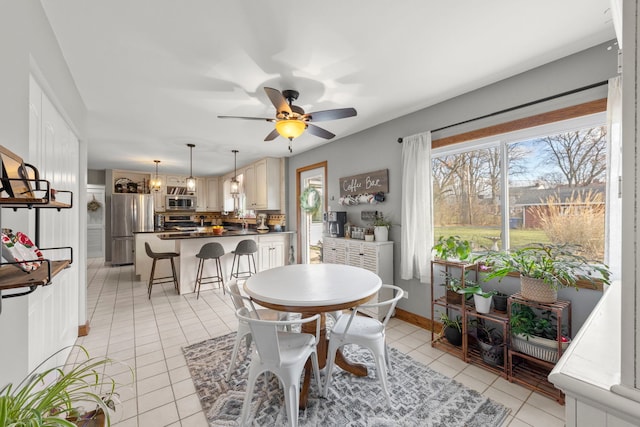 tiled dining room with ceiling fan with notable chandelier