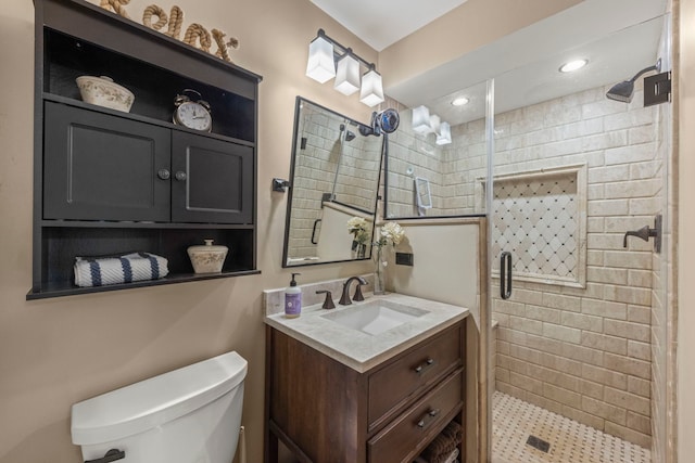 bathroom with vanity, toilet, and a shower with door