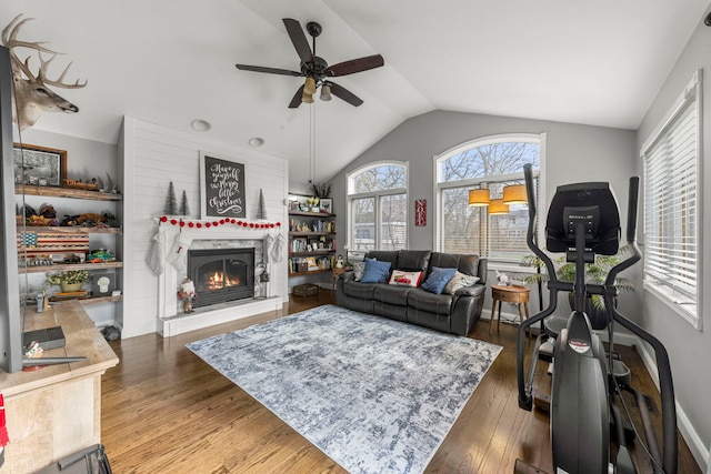 living room with wood-type flooring, ceiling fan, and lofted ceiling