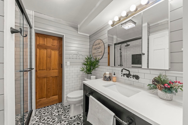 bathroom featuring toilet, vanity, tile walls, and walk in shower