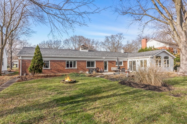 rear view of house with a lawn, a patio area, and an outdoor fire pit