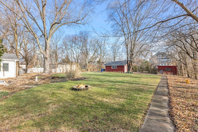 view of yard featuring a fire pit and a storage unit