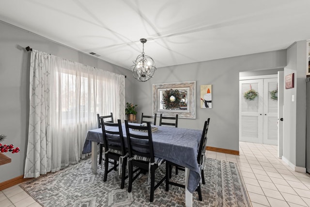 dining room featuring a wealth of natural light, light tile patterned floors, and a chandelier