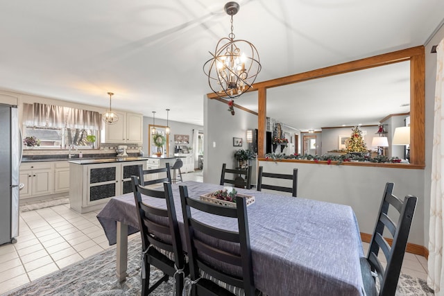 tiled dining room featuring sink and a chandelier