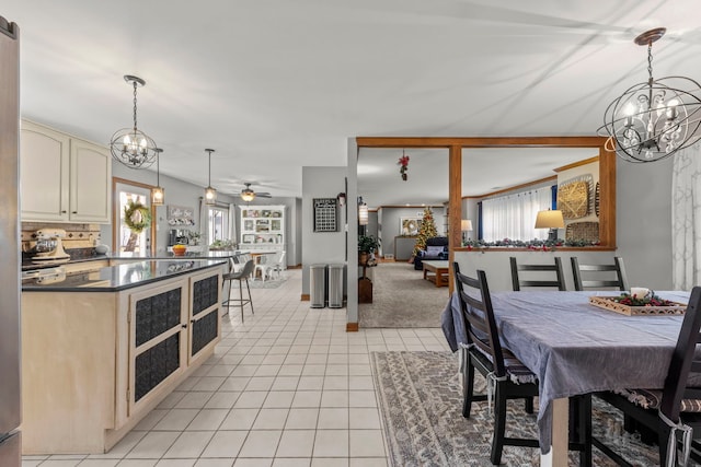 dining area with ceiling fan with notable chandelier and light tile patterned floors