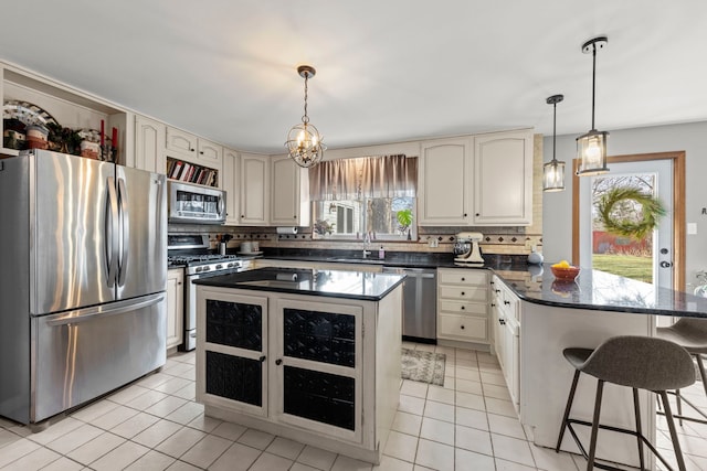 kitchen with hanging light fixtures, stainless steel appliances, a kitchen island, and a wealth of natural light