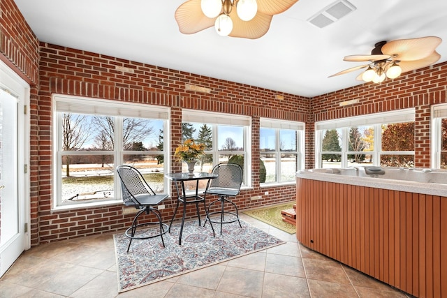 sunroom featuring ceiling fan and a healthy amount of sunlight