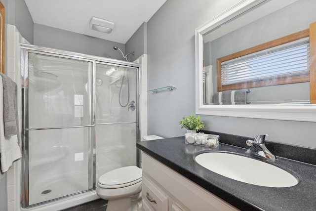 bathroom featuring vanity, toilet, and an enclosed shower