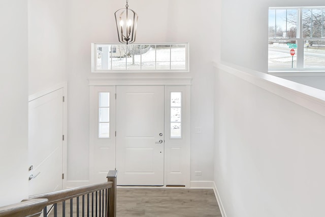 entrance foyer featuring plenty of natural light, light hardwood / wood-style flooring, and an inviting chandelier