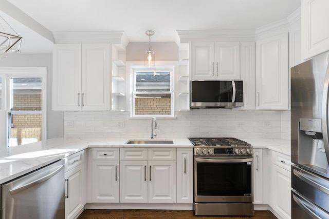 kitchen with white cabinetry, stainless steel appliances, decorative light fixtures, and sink