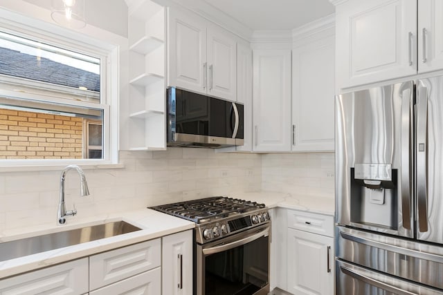 kitchen featuring appliances with stainless steel finishes, sink, white cabinets, and decorative backsplash