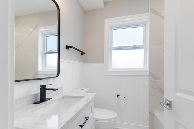 bathroom featuring vanity, a healthy amount of sunlight, and toilet