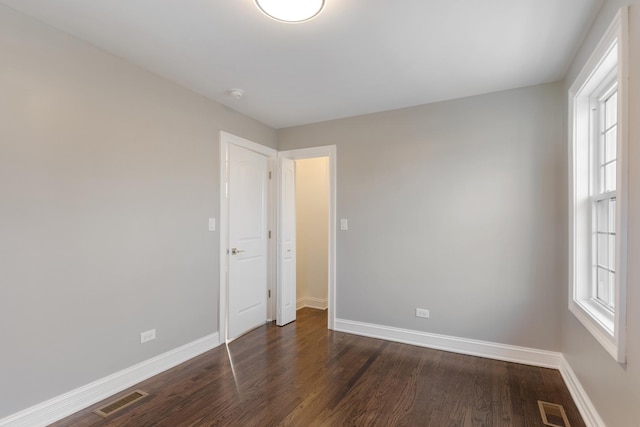 unfurnished room with dark wood-type flooring