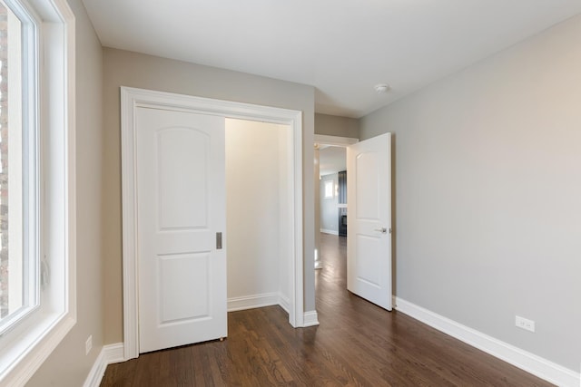 unfurnished bedroom featuring dark hardwood / wood-style flooring and a closet